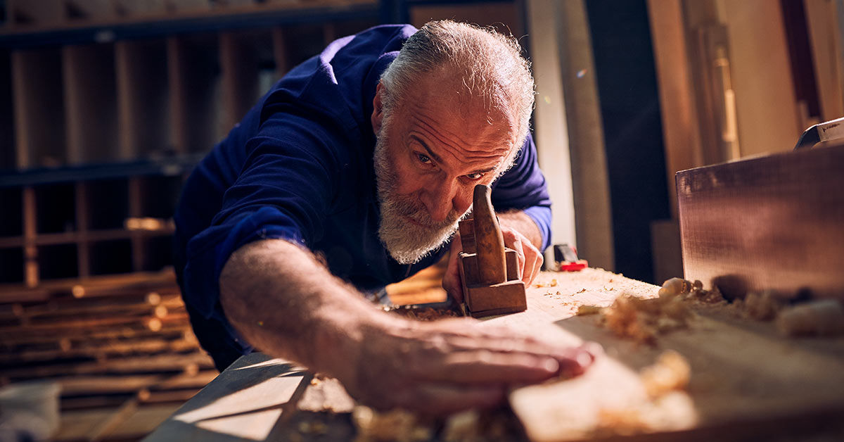 Älterer Handwerker bei der Arbeit in der Holzwerkstatt
