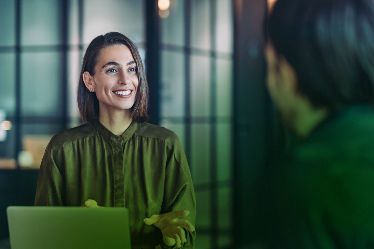Frau mit Laptop spricht mit Mann