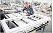 Ein Mann arbeitet an einem PVC-Türrahmen auf einer Werkbank in einer Fabrik