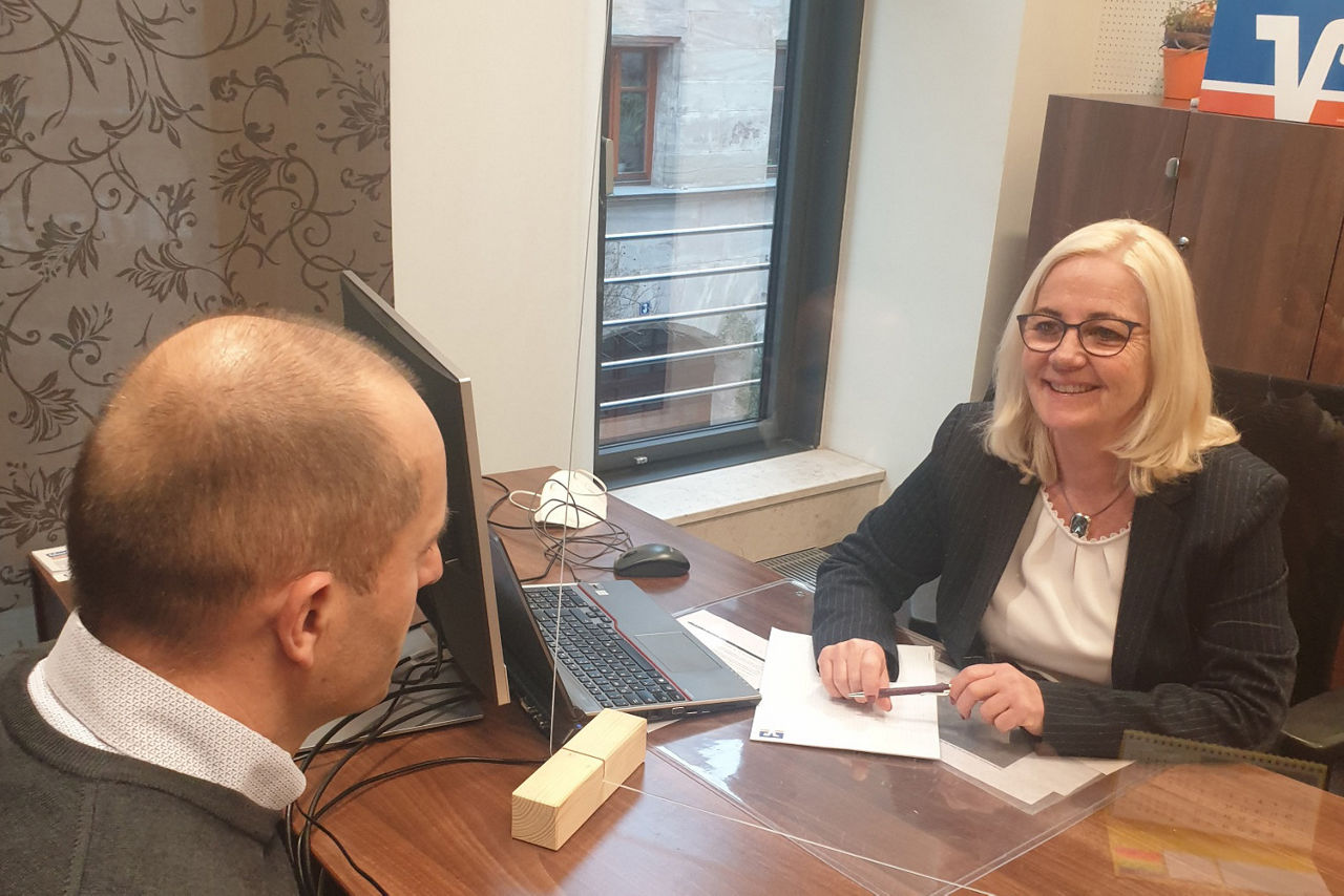 Baufinanzierungsspezialistin sitzt mit Kunden im Beratungsgespräch