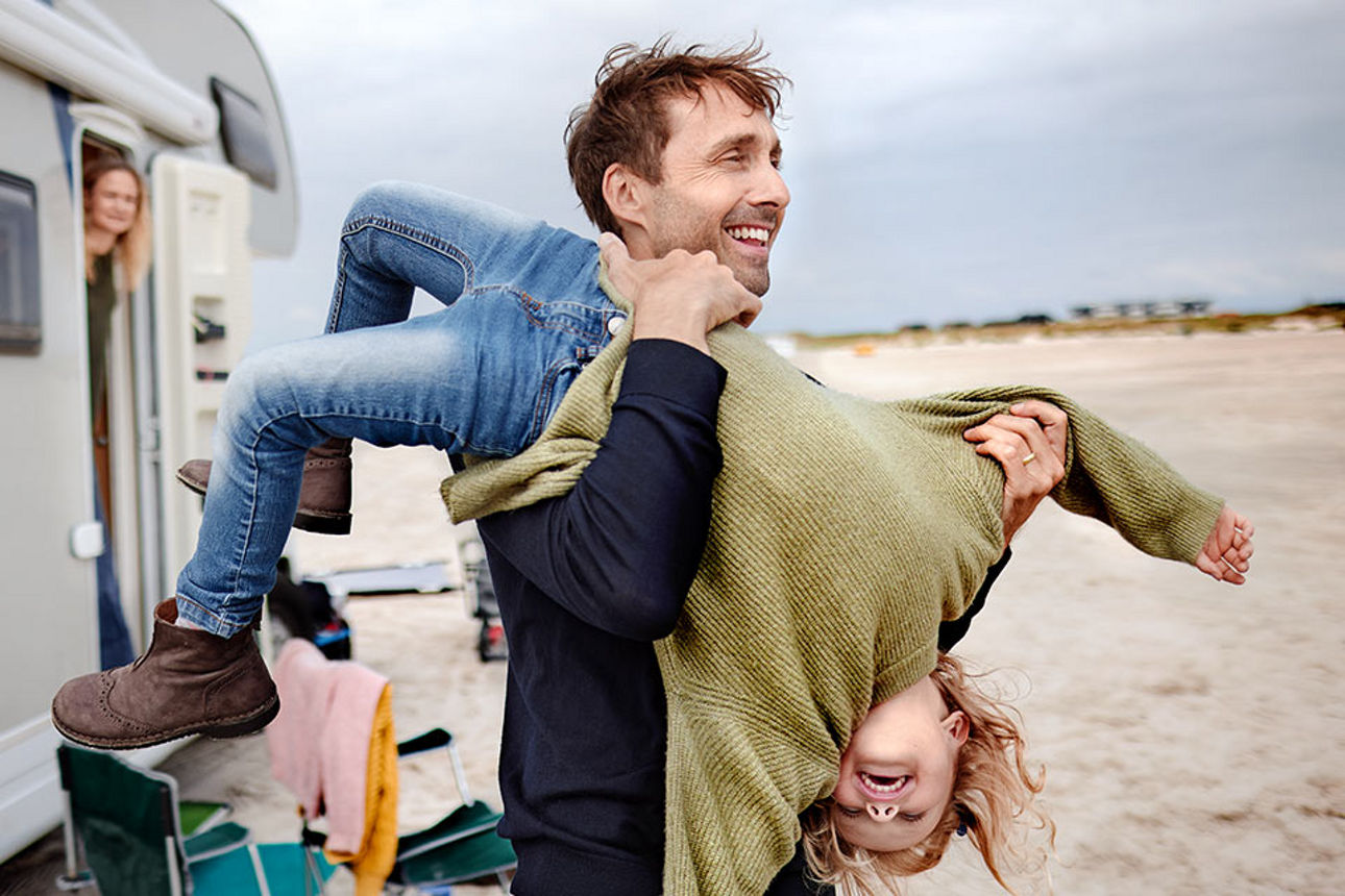Eine Vater, der seine Tochter hochhebt 