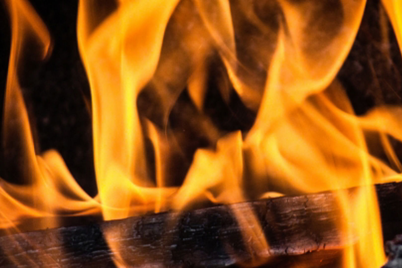 Nahaufnahme der leuchtend orangefarbenen Flammen eines Feuers.