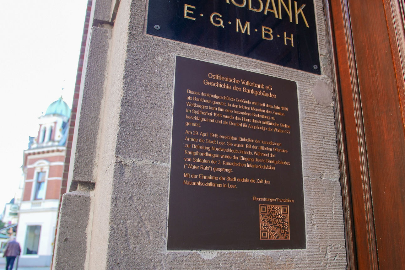 Ein Foto der Bronzetafel, die an der linken Seite des alten Bankeingangs eingelassen ist