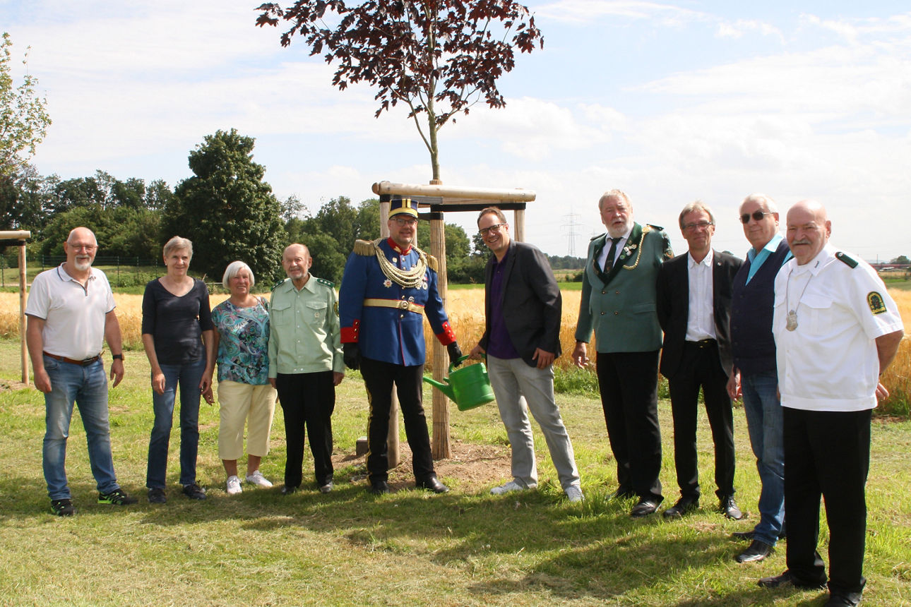 Gruppe von Männern und Frauen auf einem Feld, Gruppenfoto während eines erfolgreichen Crowdfunding-Projekts in Delrath.