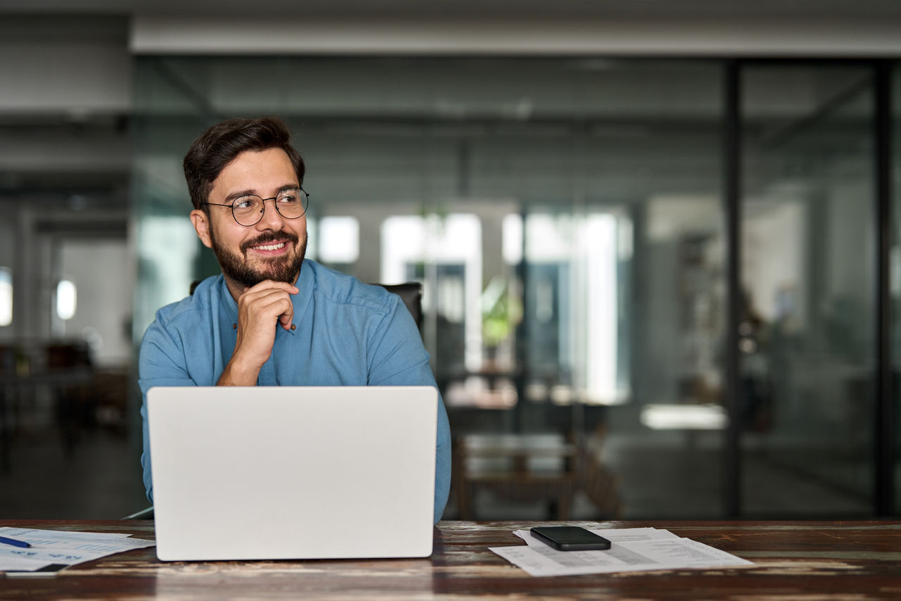 Mann am Schreibtisch sitzend mit Laptop