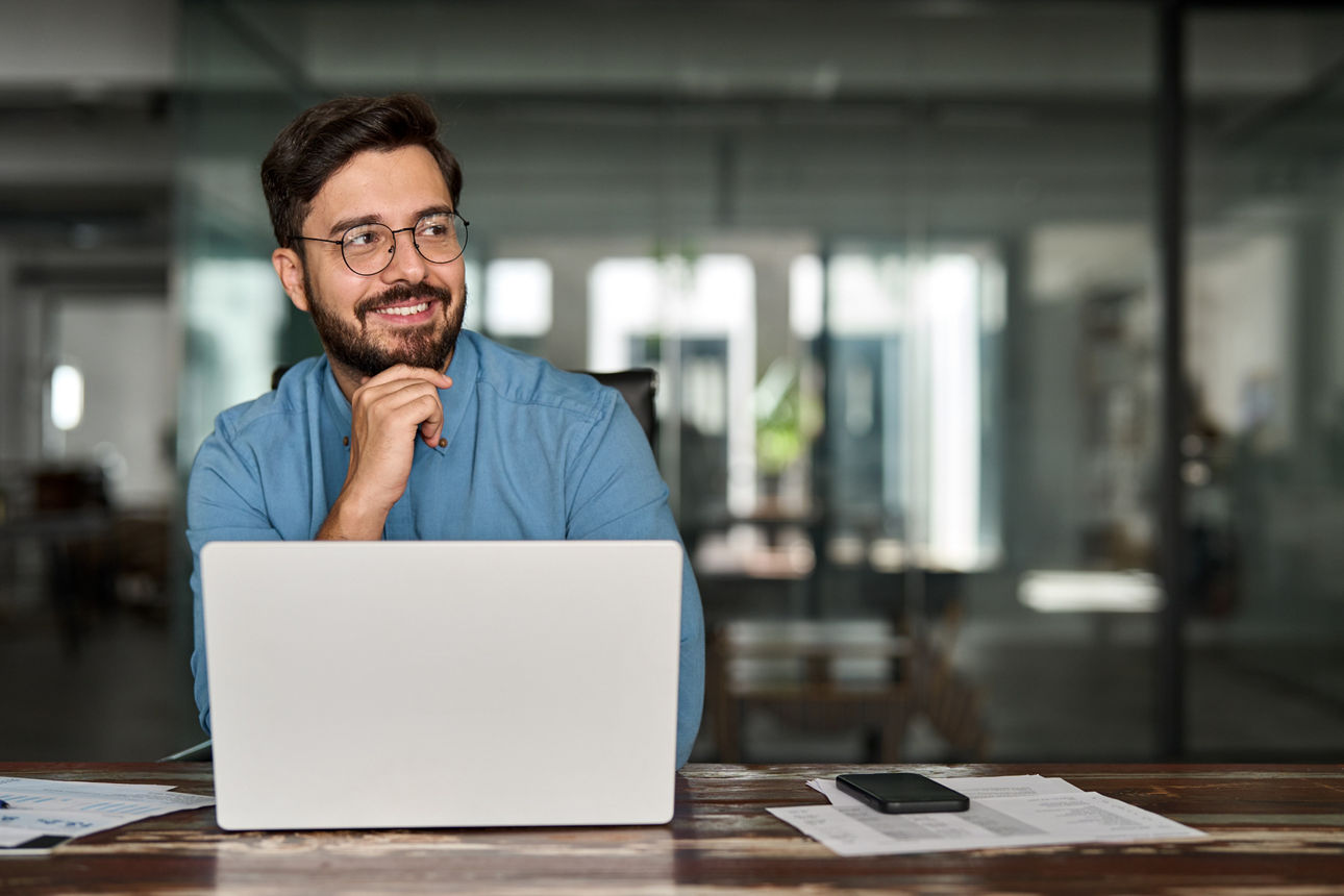 Mann am Schreibtisch sitzend mit Laptop