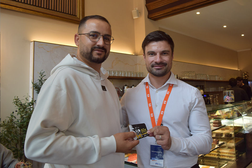 Sebastian Wähner und Eyüp Kahriman bei der Gutscheinübergabe im Cafe Schiller