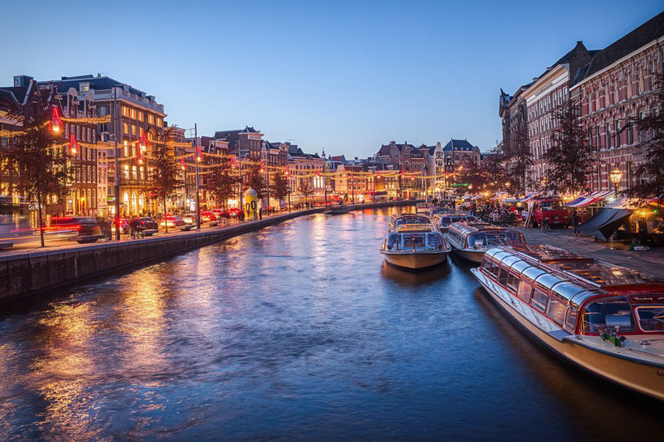 Amsterdamer Kanal mit Booten und beleuchtete Häuser