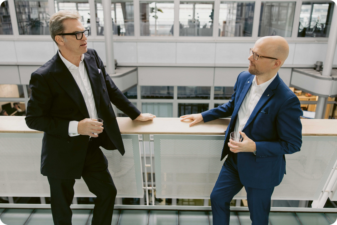 Carsten Jung und Sebastian Strietzel stehen an einem Geländer und unterhalten sich