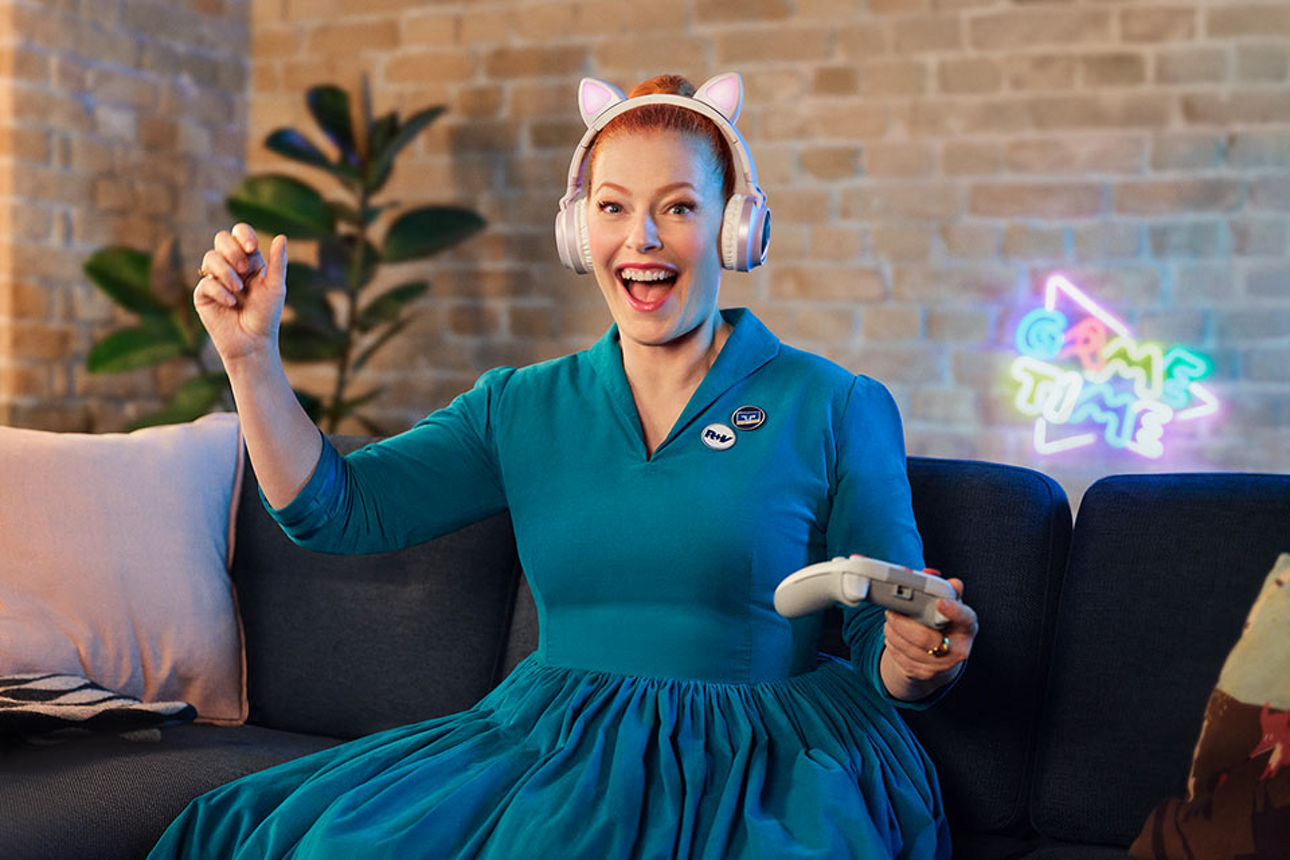 Blonde Frau liegt in einer Hängematte im Wald vor einem See.