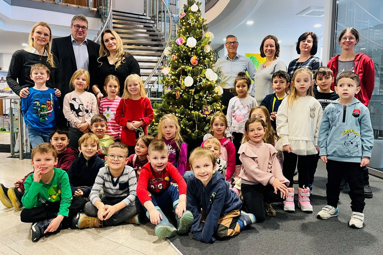 Vorschulkinder schmücken Christbaum
