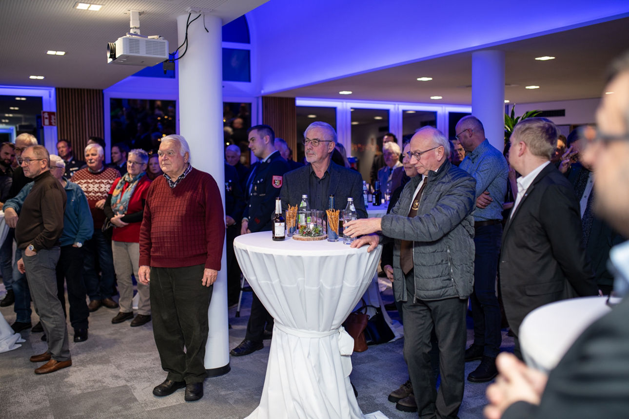 Menschen in einem Hörsaal an Stehtischen