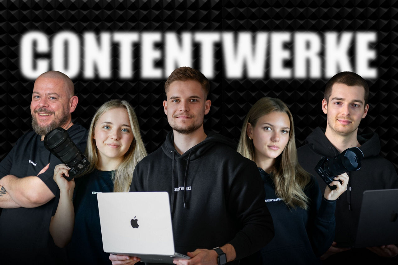 Fünf Personen in schwarzen Hoodies stehen zusammen. Zwei Personen halten einen Laptop, während zwei andere eine Kamera tragen. Der Hintergrund zeigt den Text 'CONTENTWERKE'.