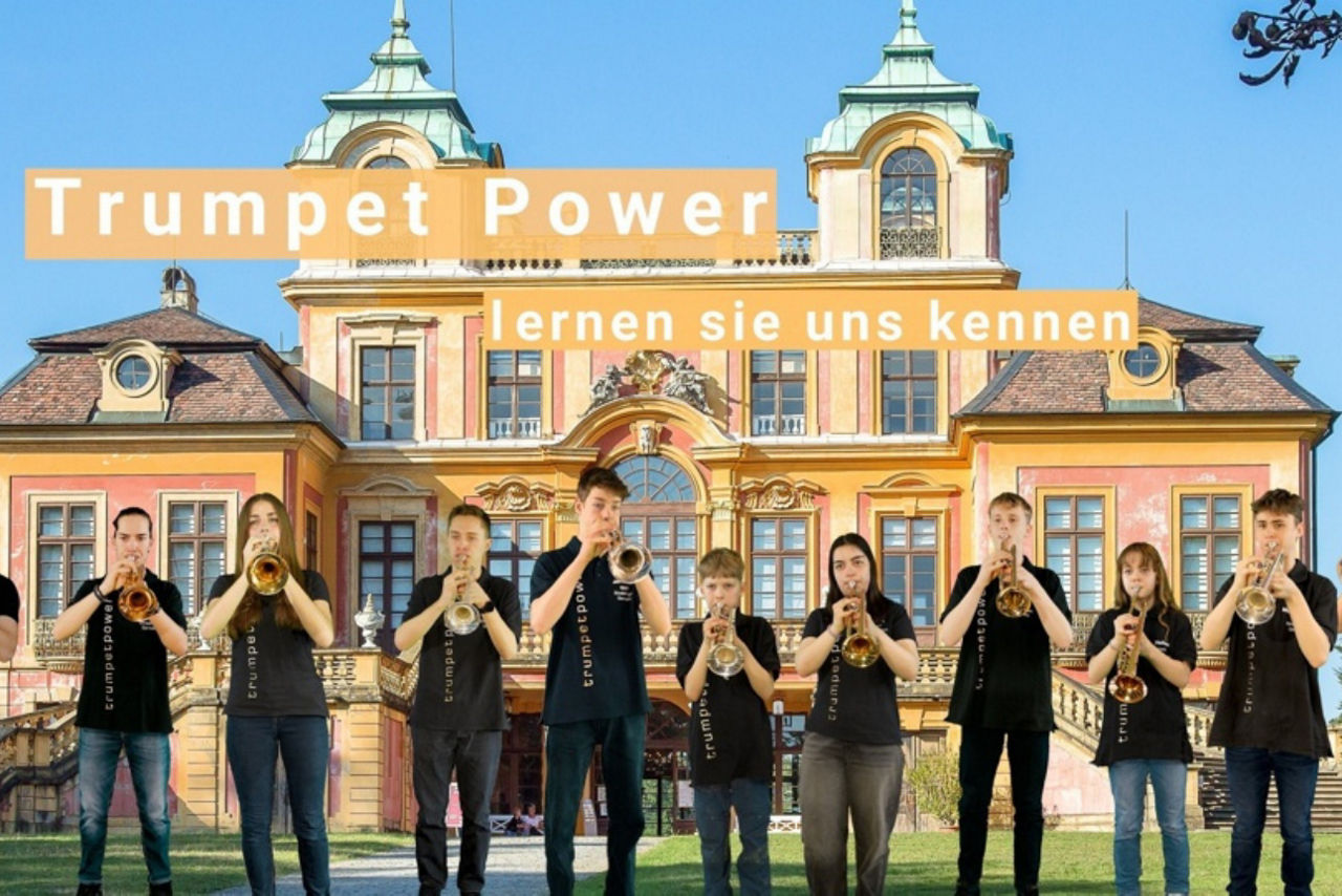 Junge Musizierende mit Trompete vor historischem Gebäude.
