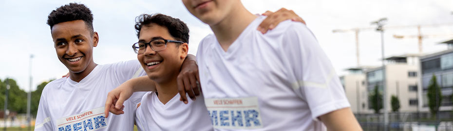 Drei Teenager in Sporthemden lächeln in die Kamera
