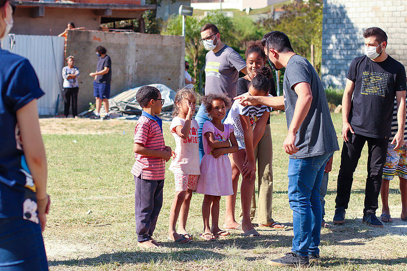 Eine Gruppe Kinder steht vor einem Mann