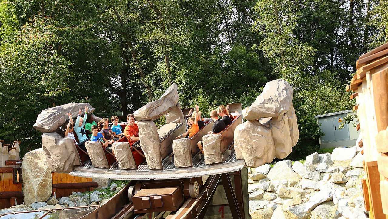 Eine Achterbahn im Bayern Park voll mit glücklichen Menschen.