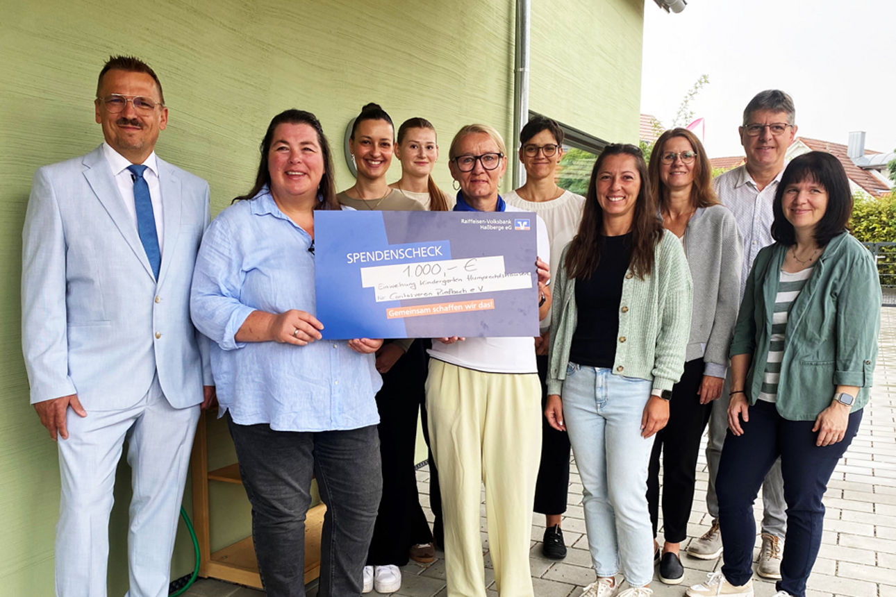 Wilma Dütsch übergibt einen Spendenscheck an Mitarbeitende und Vorstand  des Caritasvereins Riedbach
