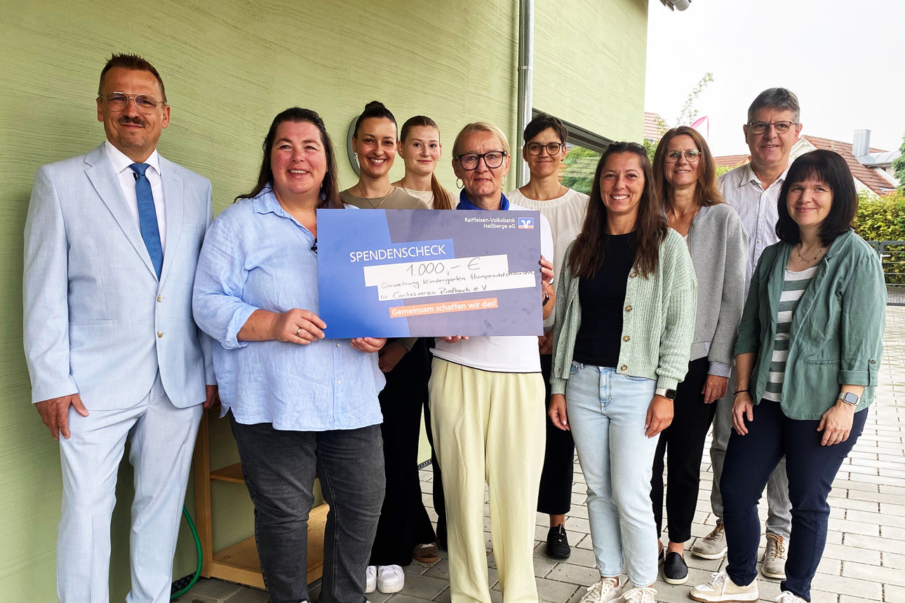 Wilma Dütsch übergibt einen Spendenscheck an Mitarbeitende und Vorstand  des Caritasvereins Riedbach