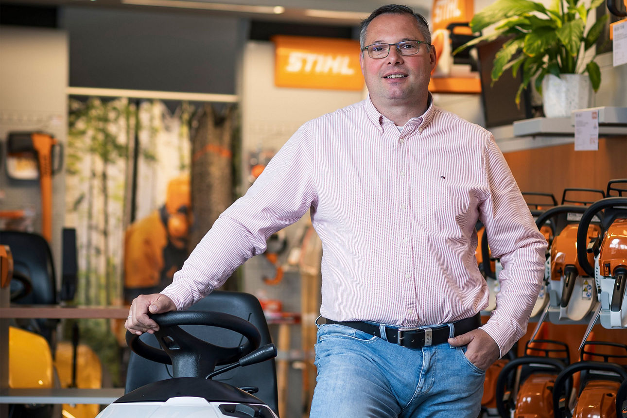 Daniel Bär steht in seinem Laden und lächelt in die Kamera.