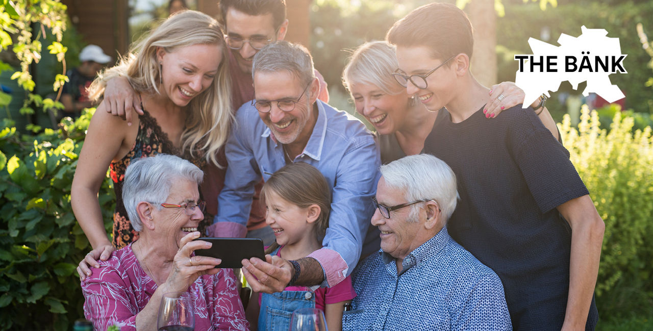 Familie schaut fröhlich zusammen auf ein Smartphone