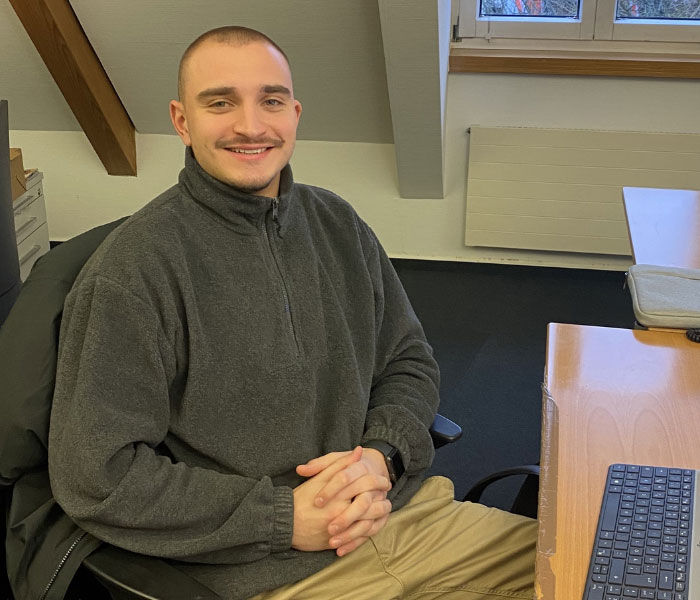 Bild von dualem Student David Alten am Schreibtisch im Büro
