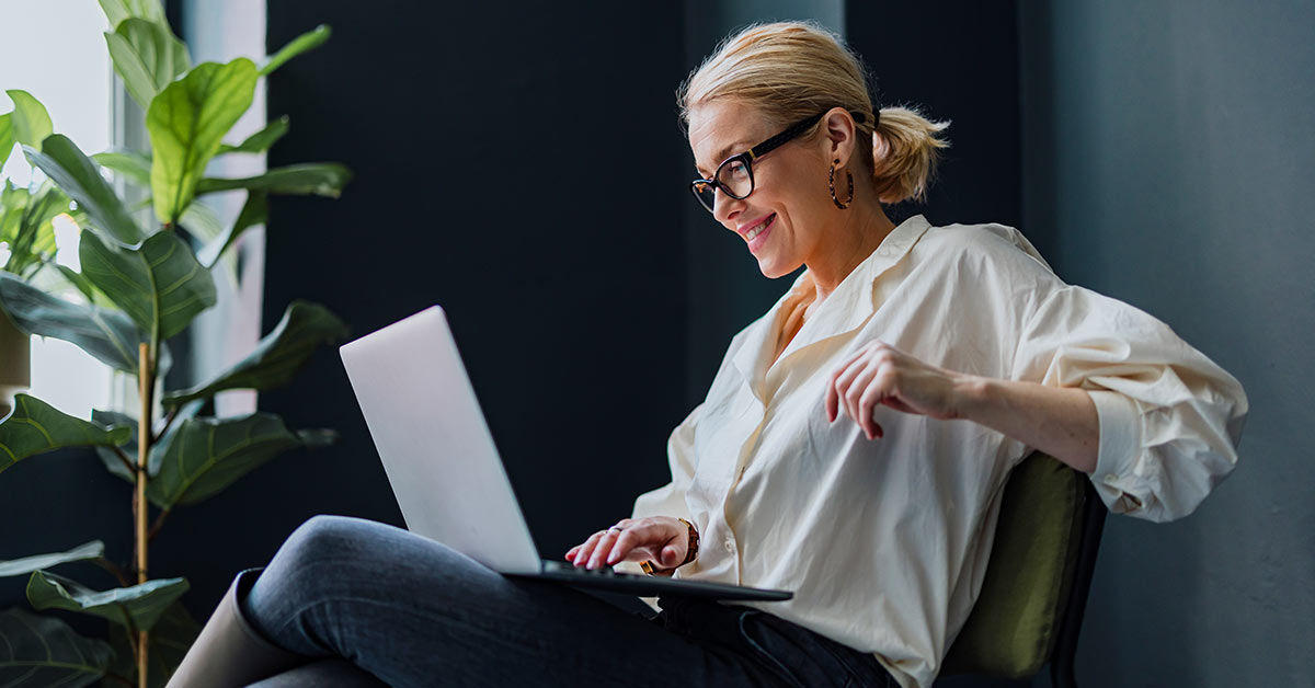 Eine Frau sitzt entspannt an ihrem Laptop