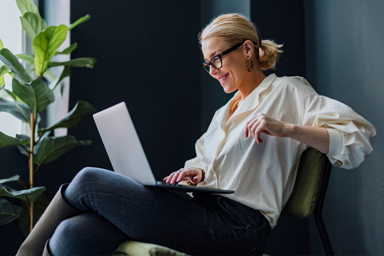 Frau sieht in Ihren Laptop.