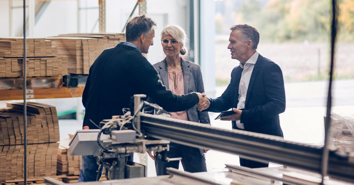 Ansprechpartner mit Händeschlag gegenüber glücklichen Kunden