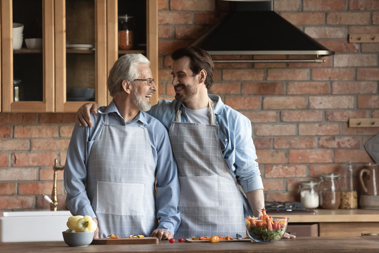 Vater und Sohn sorgenfrei in der Küche  - dank abgeschlossener Haftpflichtversicherung