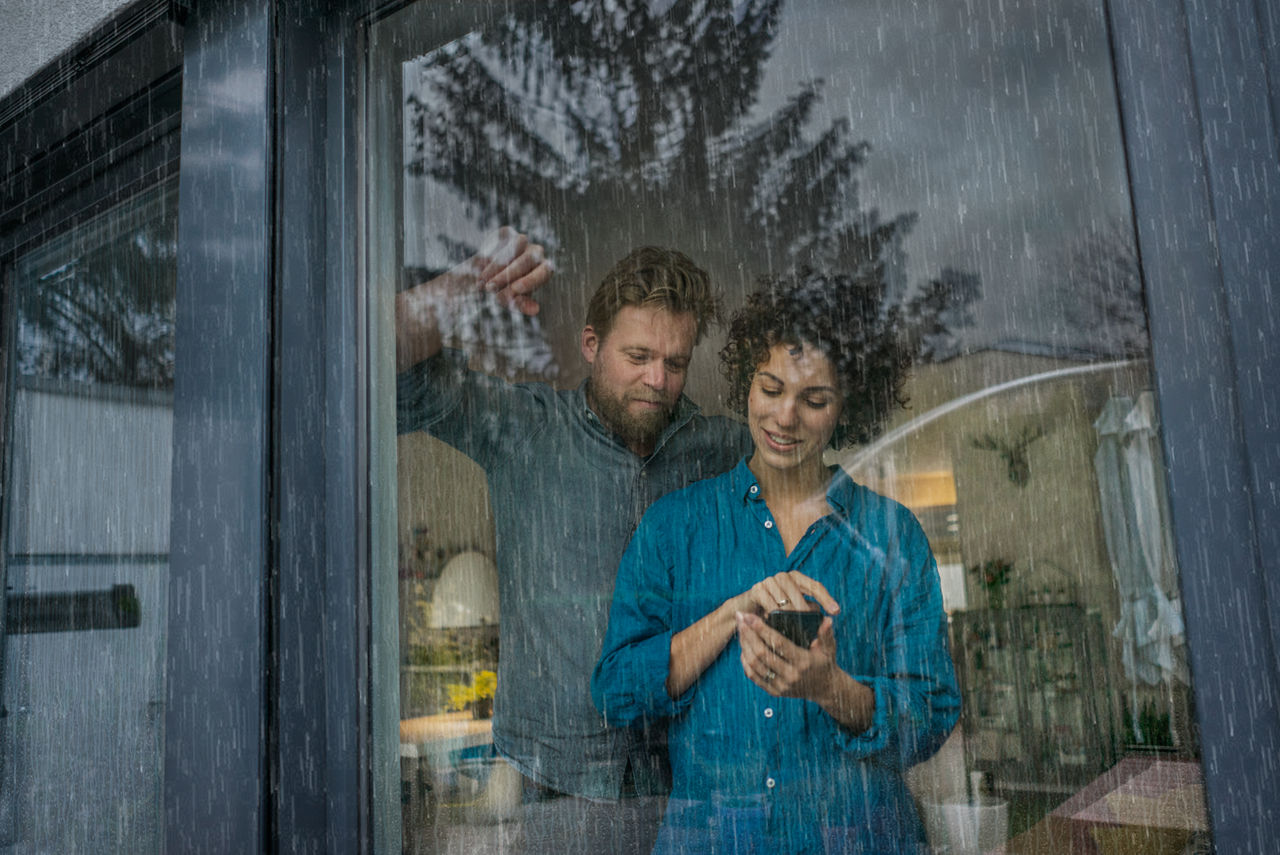 Paar schließt per Handy ihre DEVK-Wohngebäudeversicherung ab
