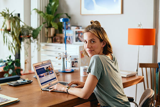 Junge Frau am Laptop stimmt im Banking ab