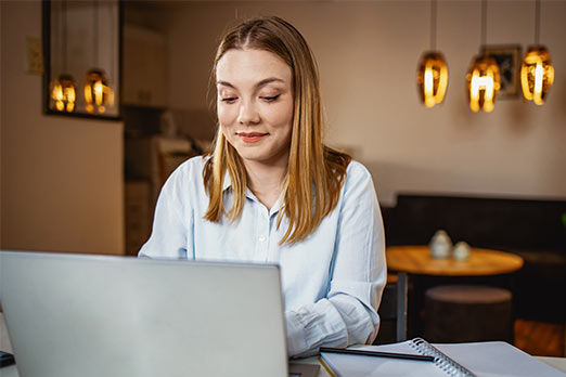 Eine junge Frau arbeitet an ihrem Laptop