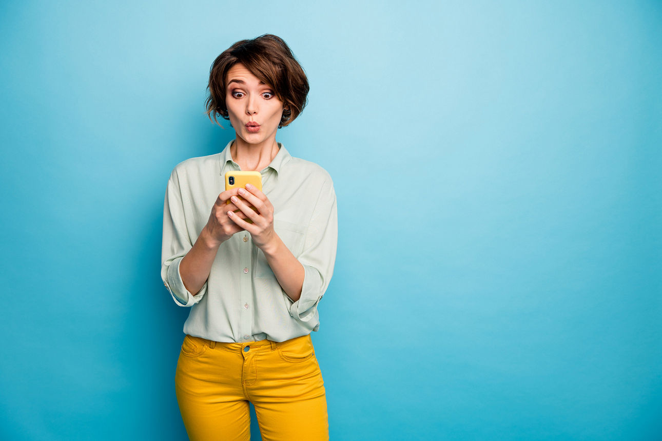 Junge Frau schaut auf ihr Smartphone.