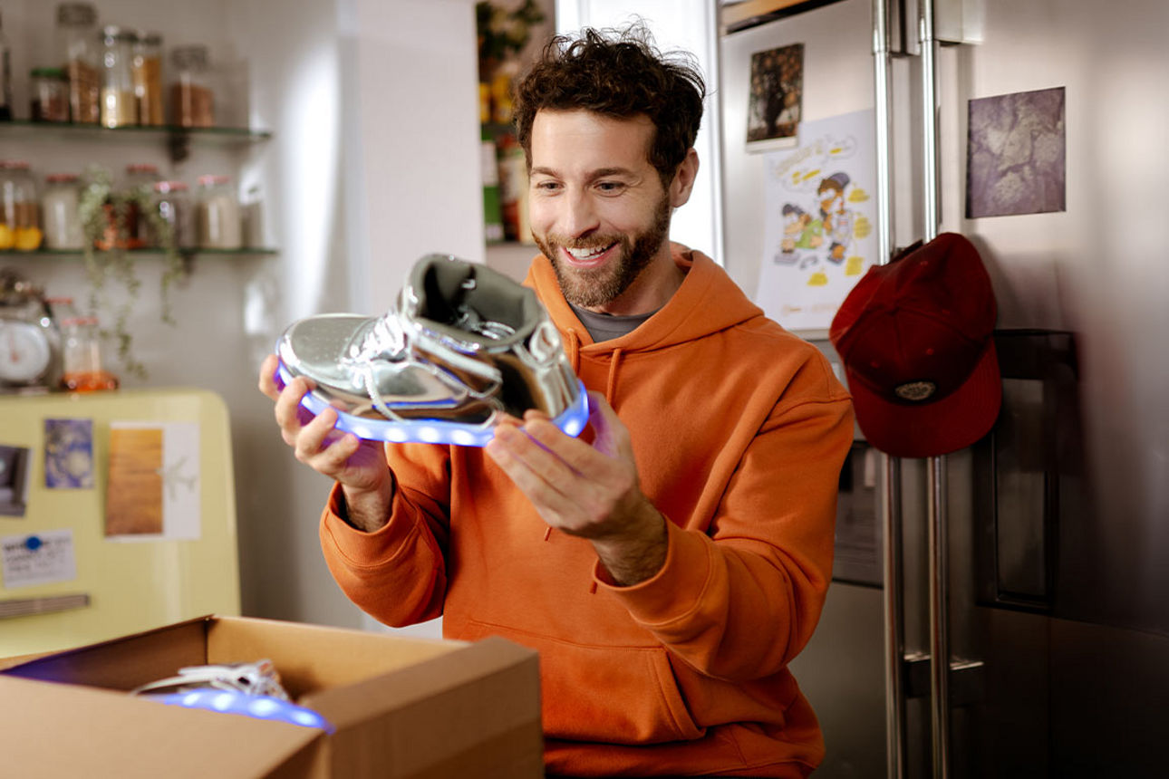 Junger Mann packt neue Sneaker aus