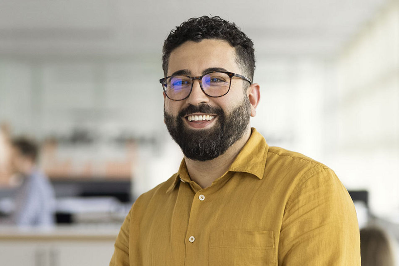 Ein Mann der freundlich in die Kamera lächelt