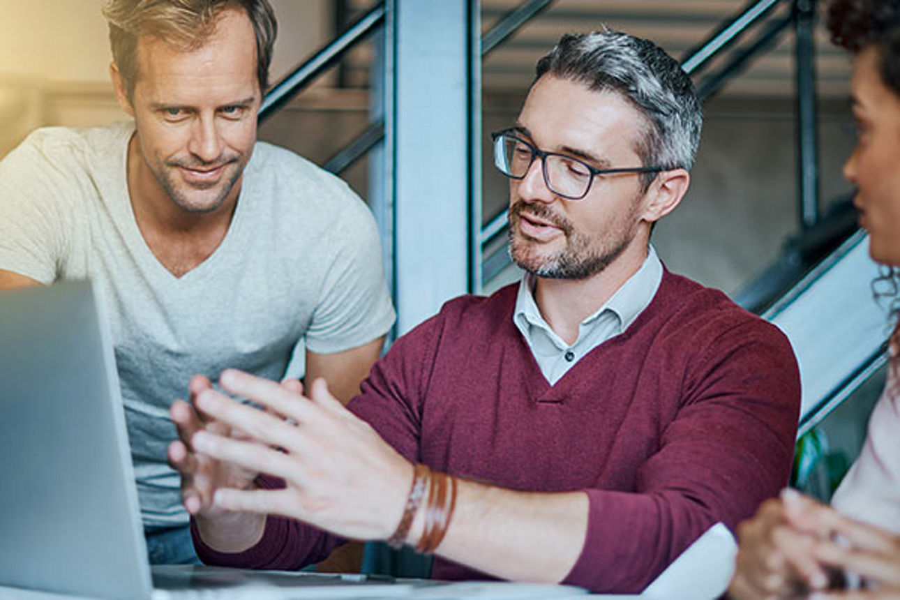 Angestellte schauen gemeinsam auf einen Bildschirm