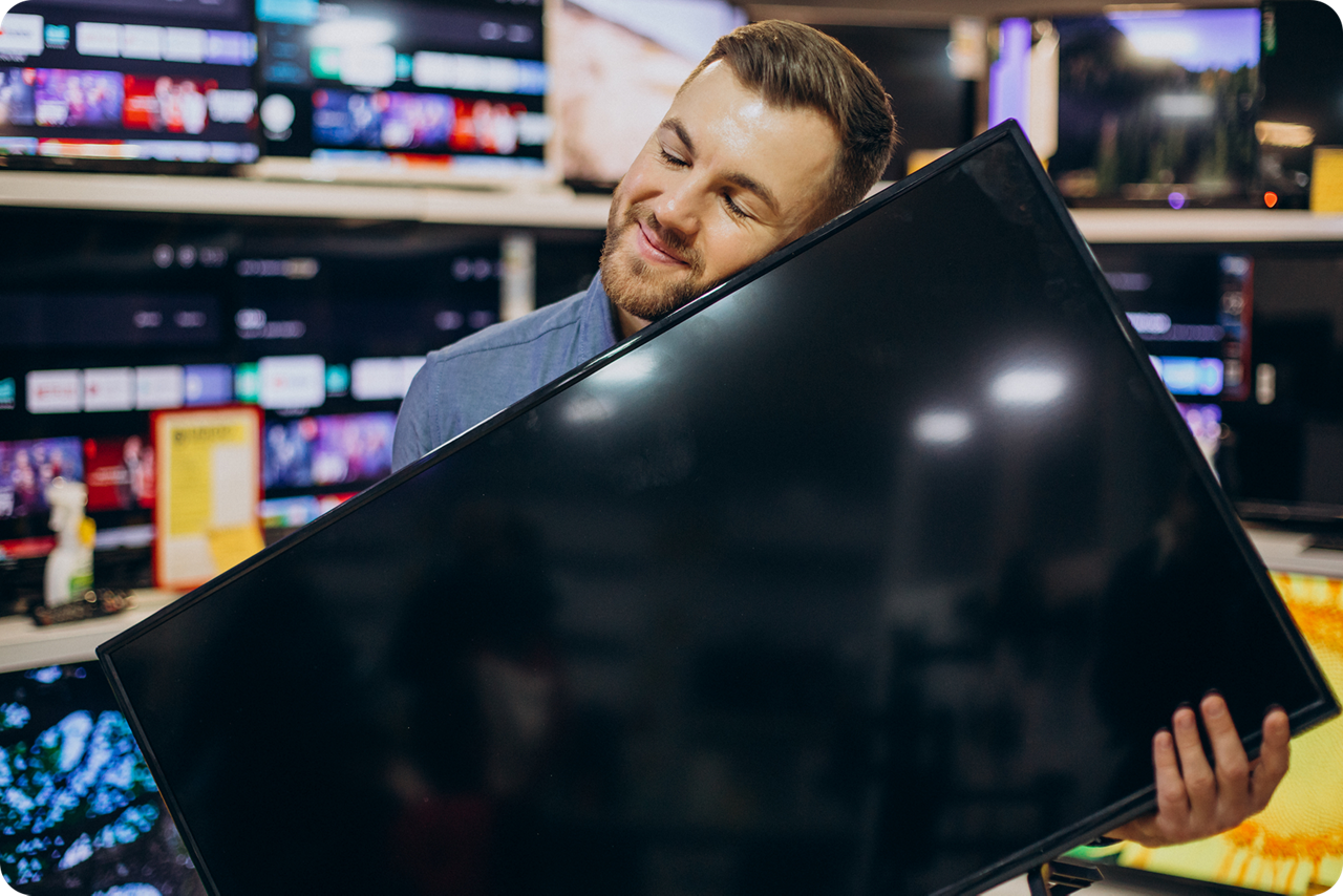 Mann hält glücklich seinen neuen Fernseher in der Hand