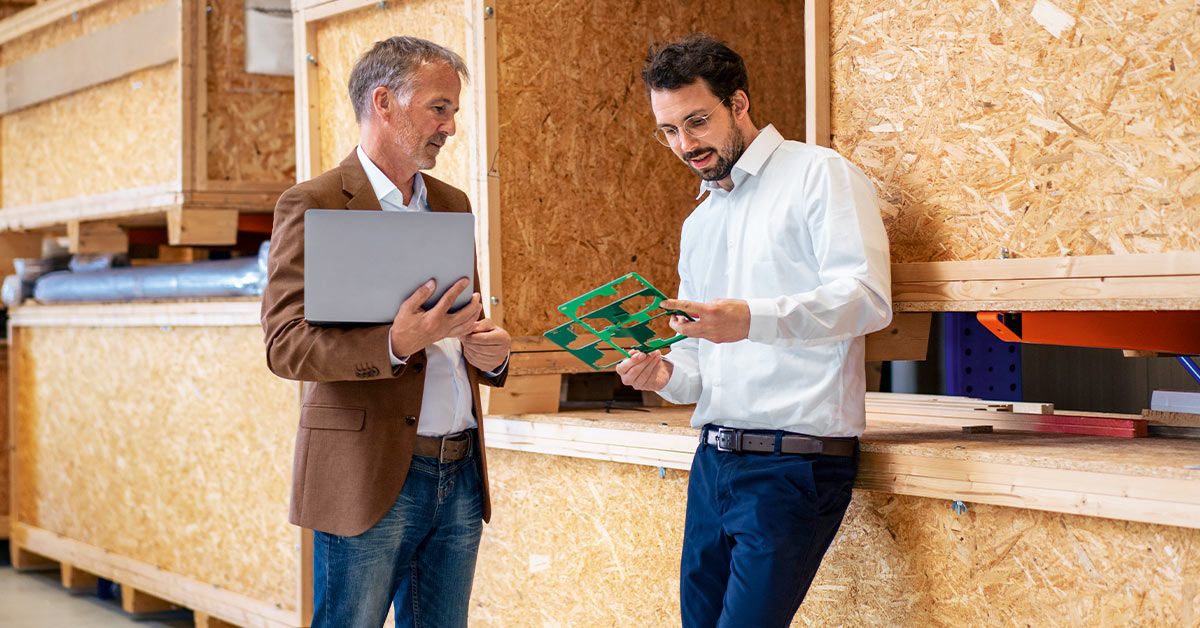 Zwei Geschäftskunden lachend mit Tablet am Arbeitstisch
