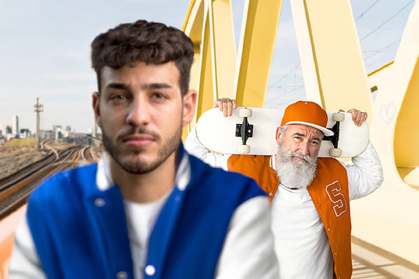 Ein junger Mann im Vordergrund, im Hintergrund steht ein älterer Mann der ein Skateboard trägt.