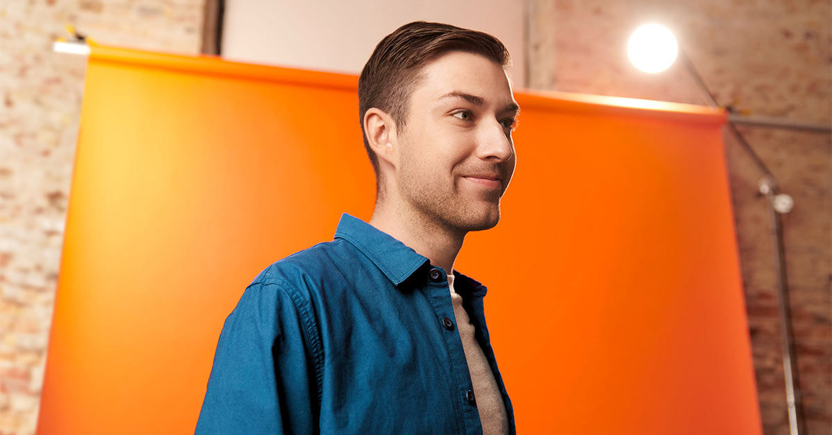 Ein Mann vor einer orangefarbenen Leinwand