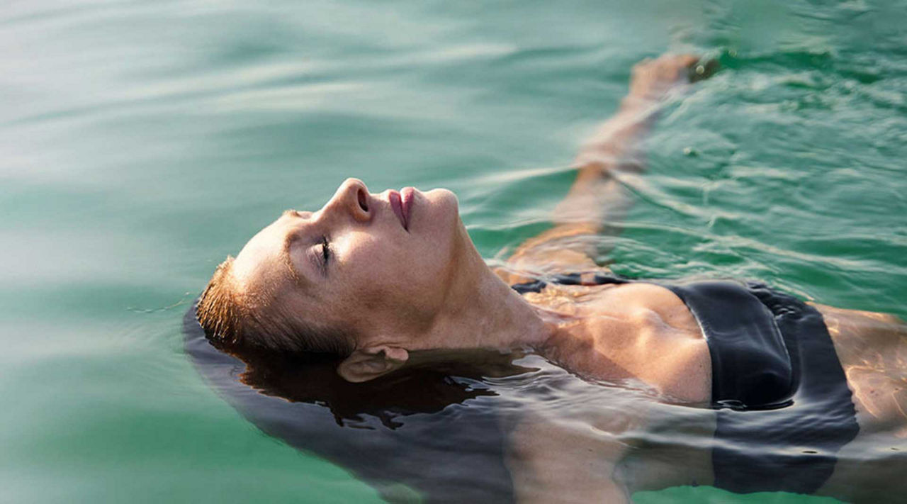 meinSparplan - Frau schwimmt auf dem Rücken im Wasser