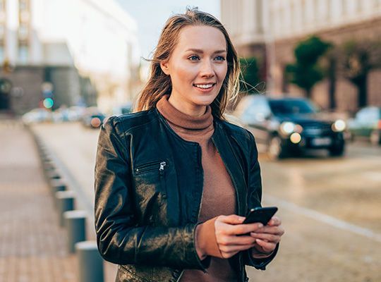 Eine junge Frau mit einem Handy in der Hand