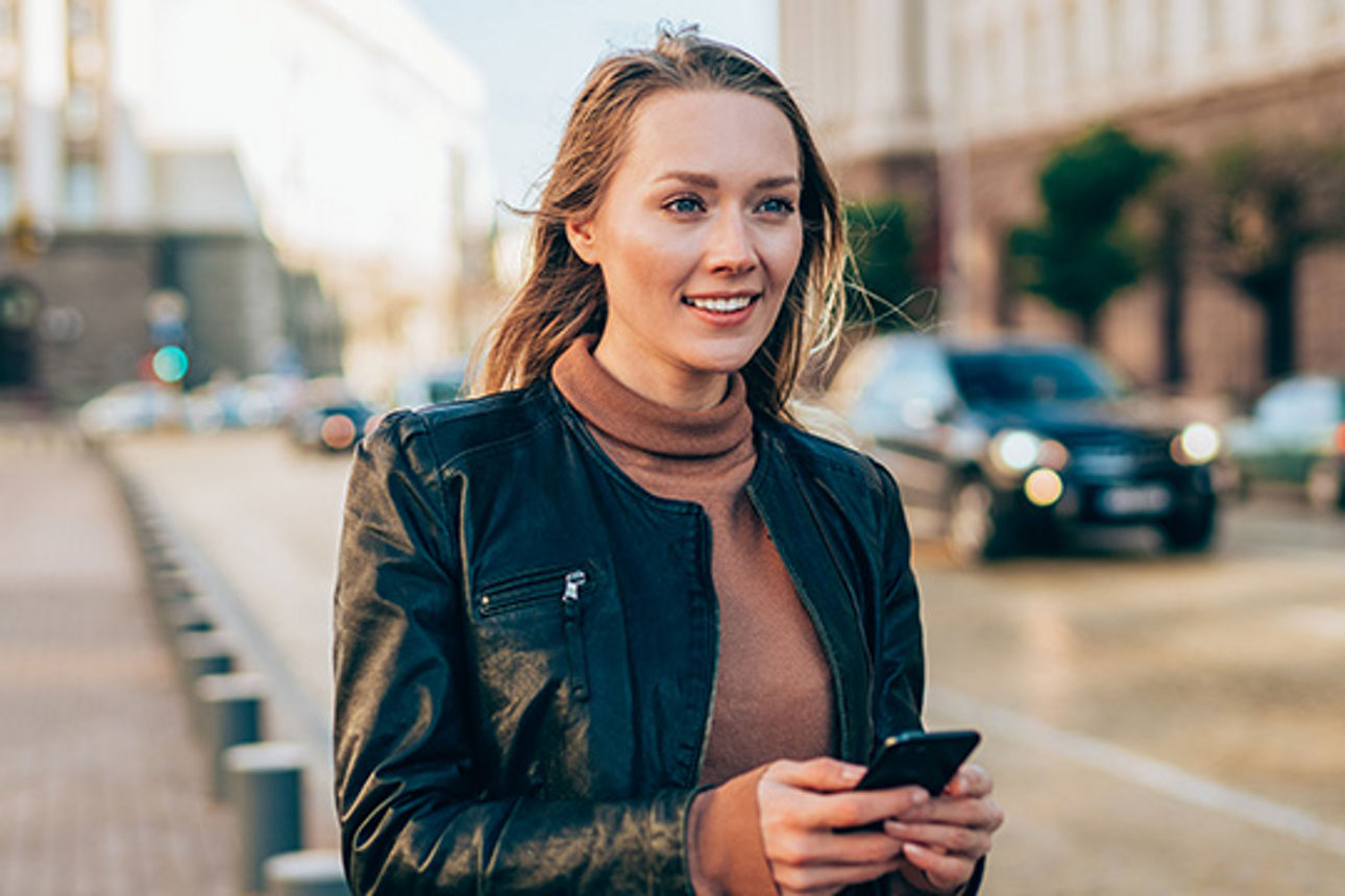 Eine junge Frau mit einem Handy in der Hand