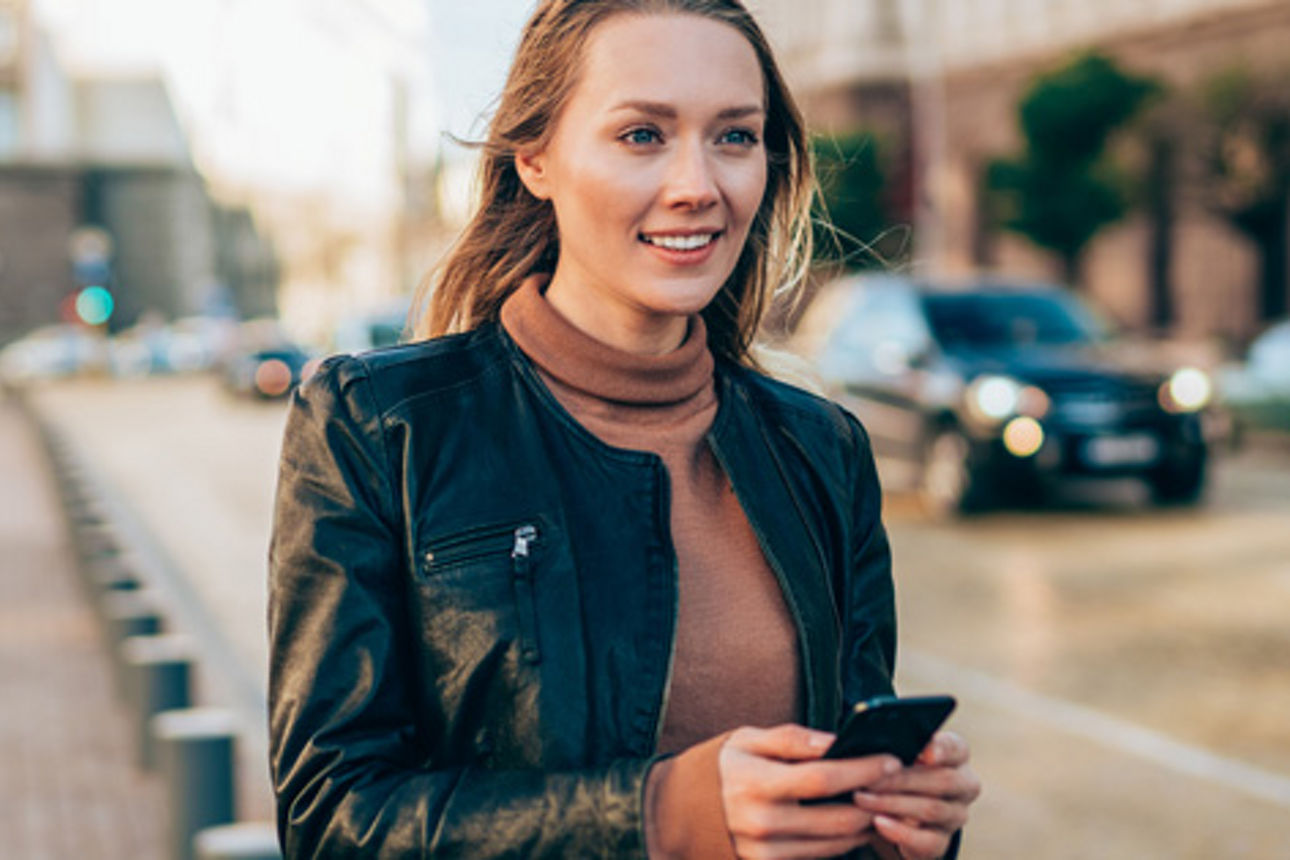 Frau mit Handy auf einer Straße