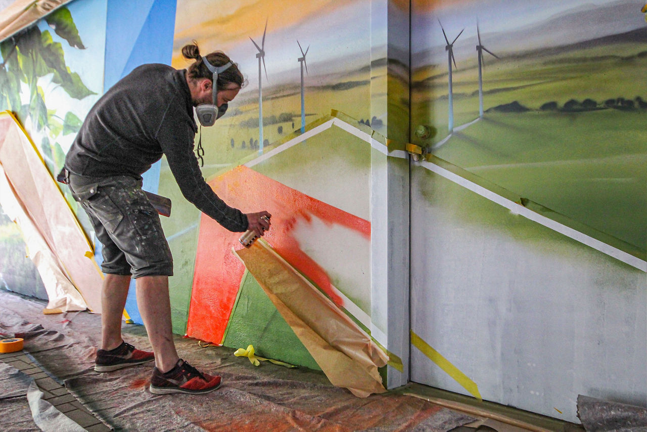 Sprayer beim erstellen des Graffitis im Parkhaus