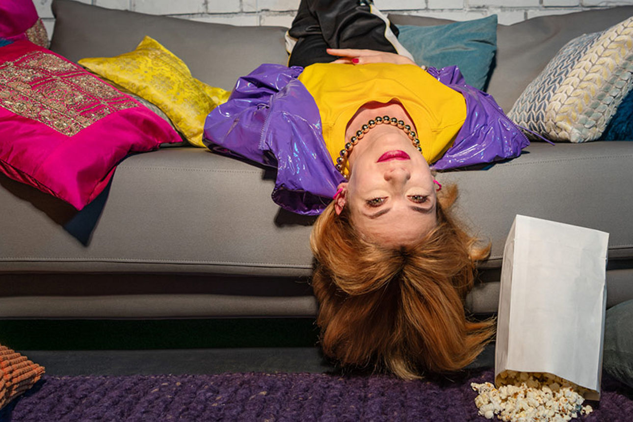 Leyla liegt kopfüber auf einer Couch