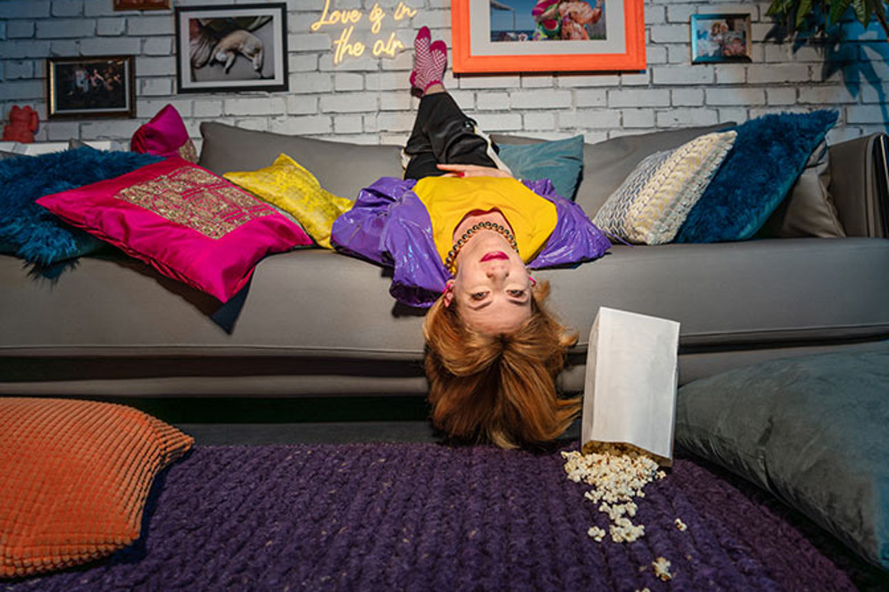 Junge Frau liegt kopfüber auf der Couch