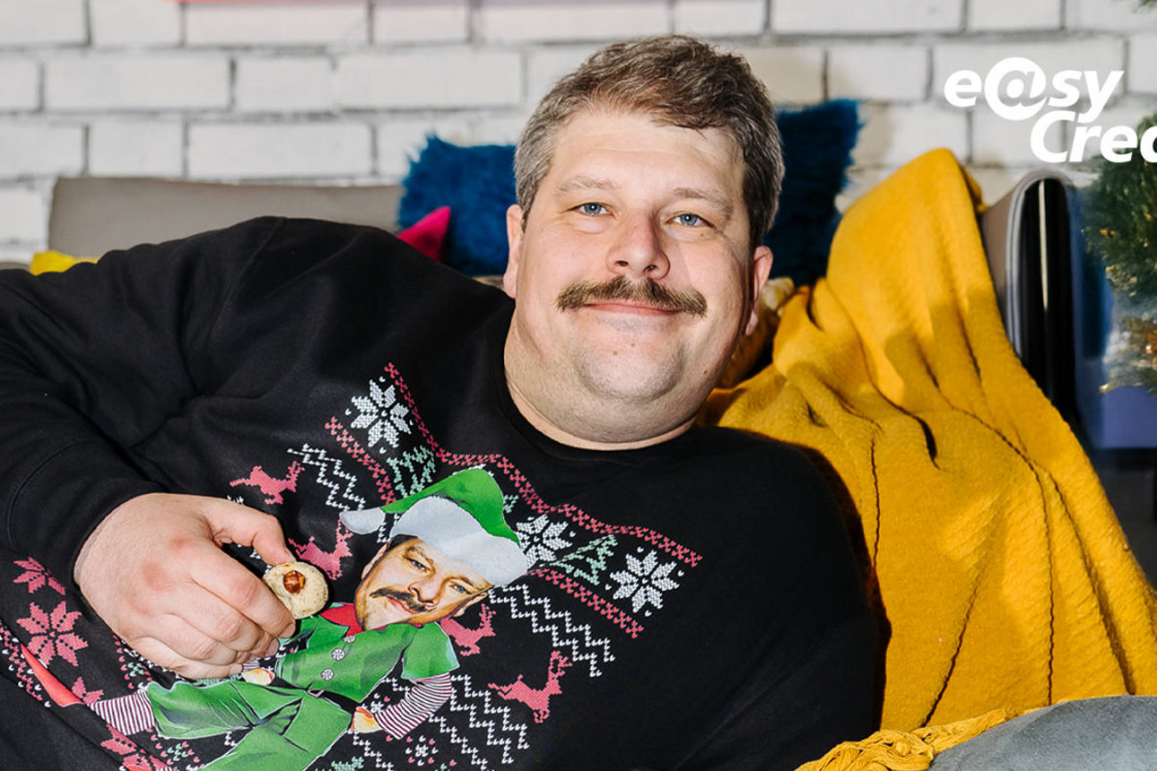 Siggi liegt im Weihnachtspulli und schaut in die Kamera