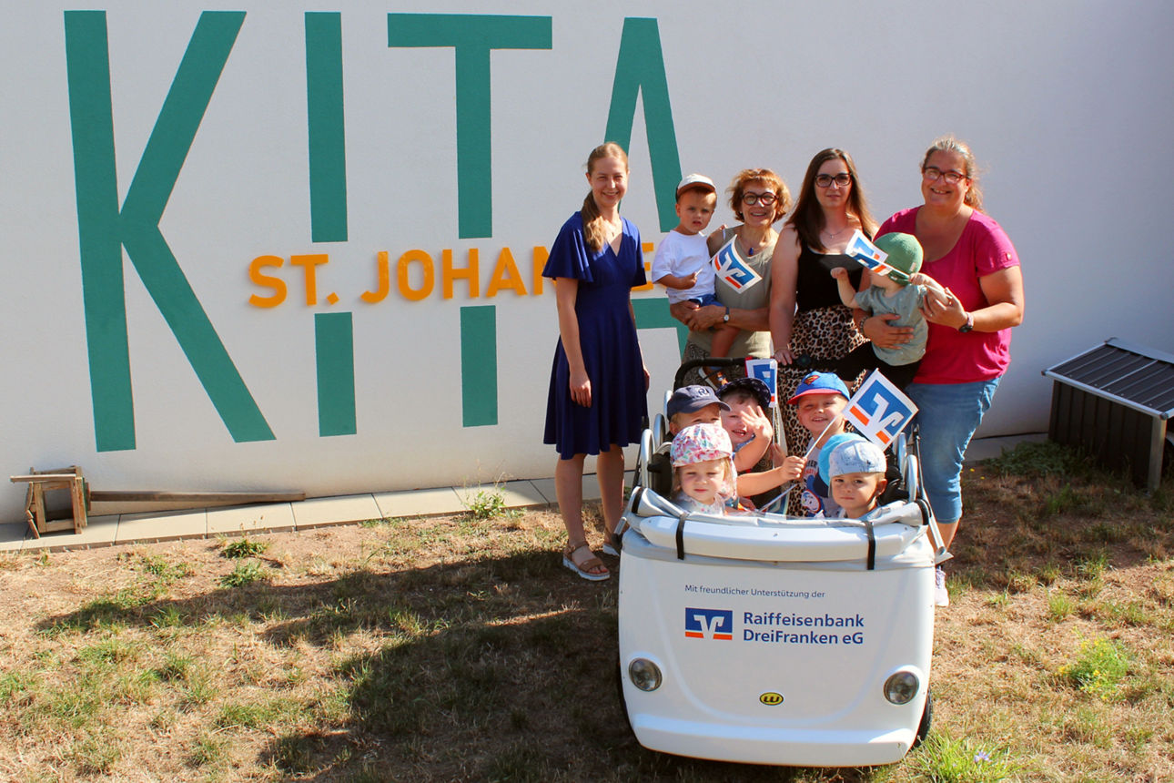 Erwachsene stehen mit den Kindern im Kinderbus vor der Kita.